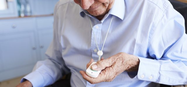 Senior Man At Home Using Distress Alarm Call Button