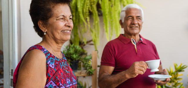 Elderly couple having a coffee in their backyard